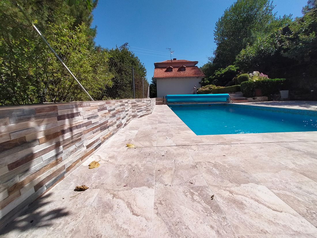 Zona de piscina reformada con suelo y paredes de baldosas cerámicas grandes