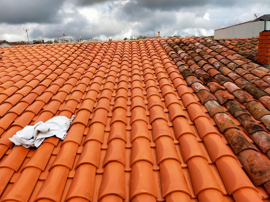 Tejado con nuevas tejas en el lado izquierdo y antiguas en el derecho