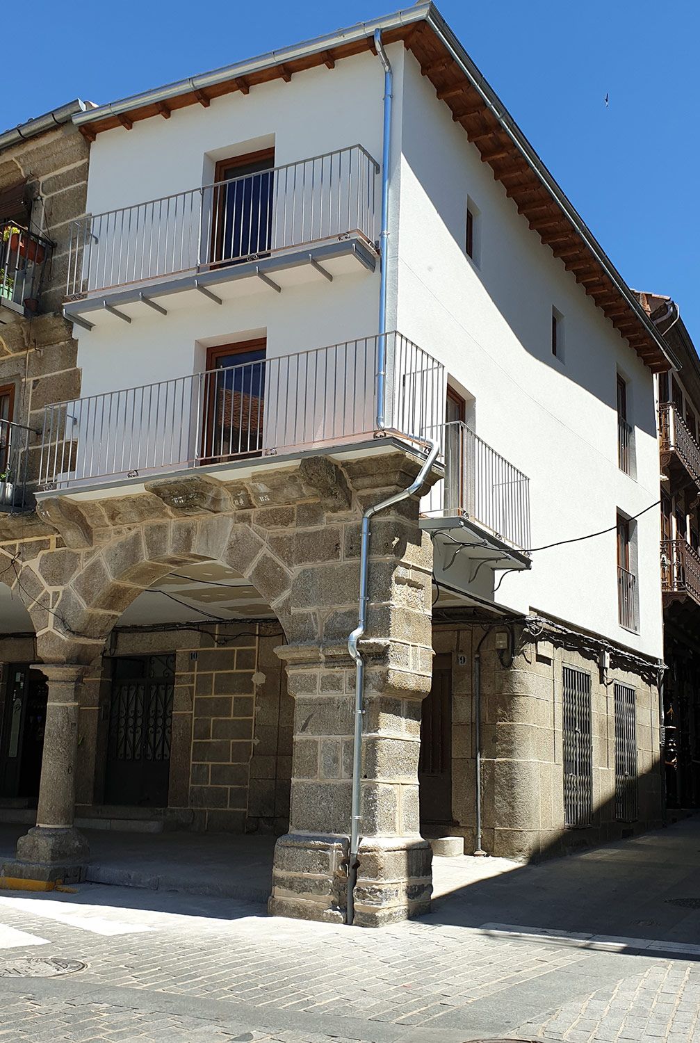 Casa antigua de plaza de pueblo con fachada restaurada