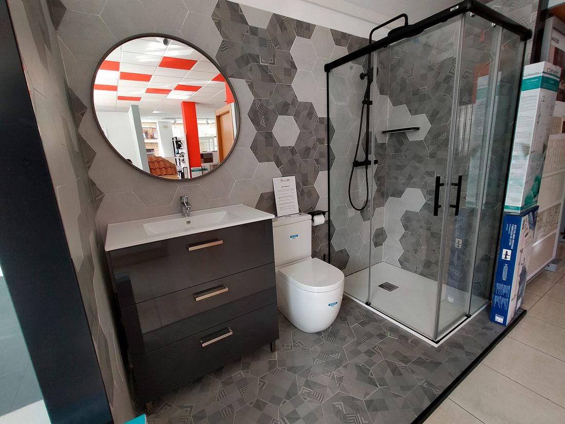 Expositor de baño con muebles, plato de ducha y sanitarios en interior de local