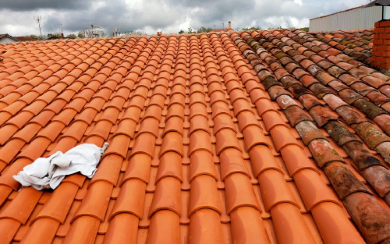 Tejado con nuevas tejas en el lado izquierdo y antiguas en el derecho