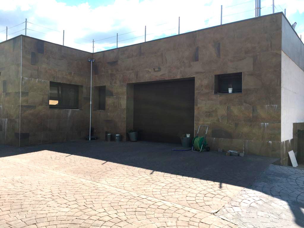 Casa moderna con exterior cerámico en tono marrón oscuro