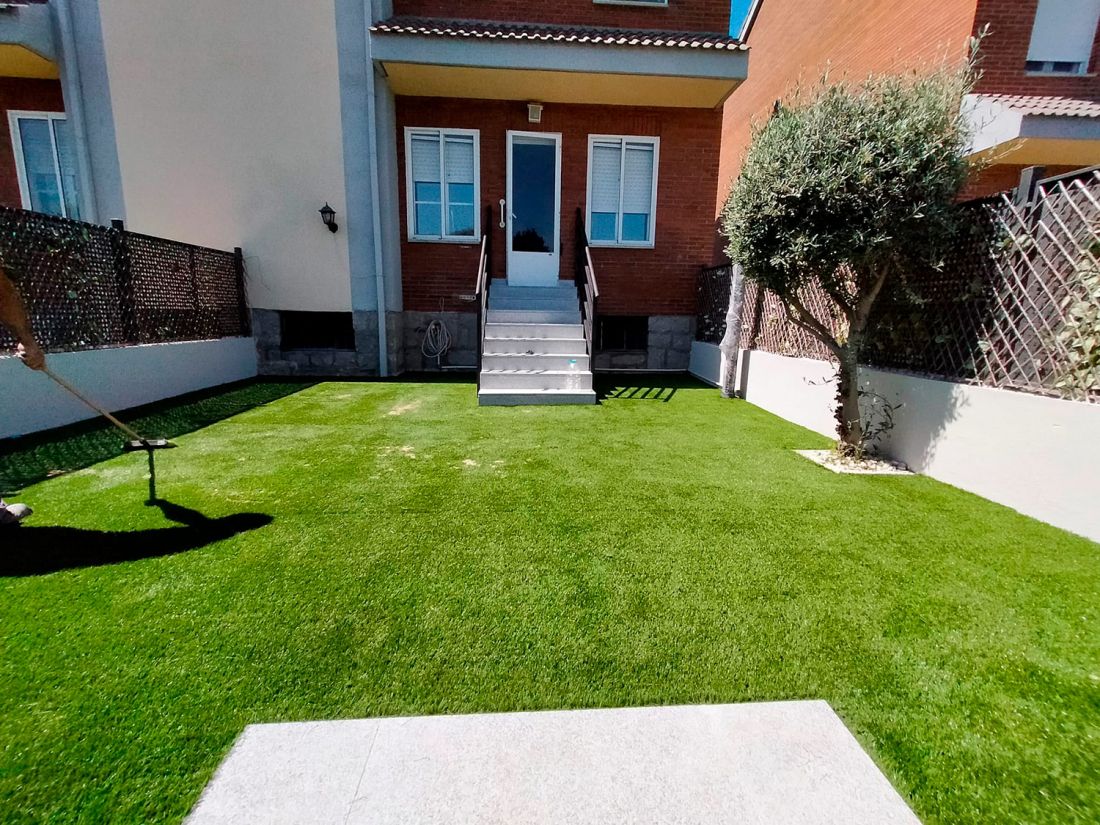 Casa unifamiliar con jardín y césped artificial